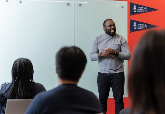 A person stands delivering a talk in front of a whiteboard at the University of Toronto Scarborough campus. (photo by Matthew Dochstader/Paradox Images)