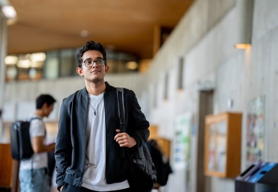 A student walks toward the photographer in the William G Davis Building at the University of Toronto Scarborough campus. (photo by Matthew Dochstader/Paradox Images)